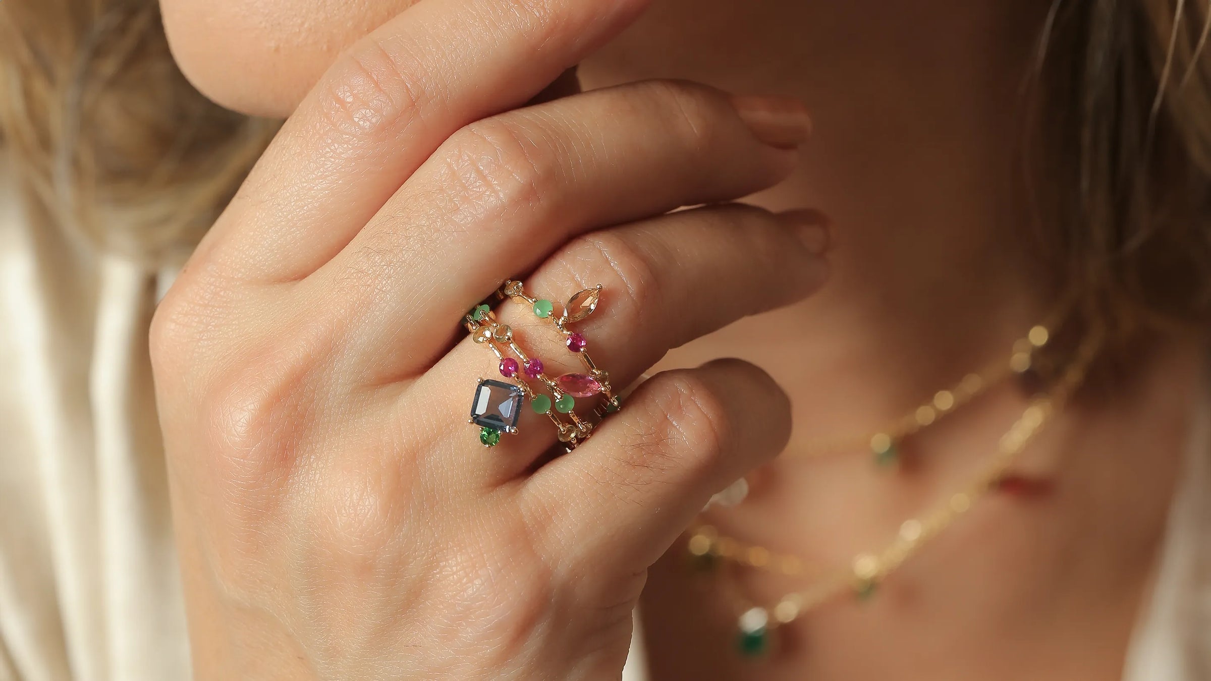 Elegant woman displaying gold-filled bracelets with intricate designs, from Elladora's sophisticated jewellery collection.