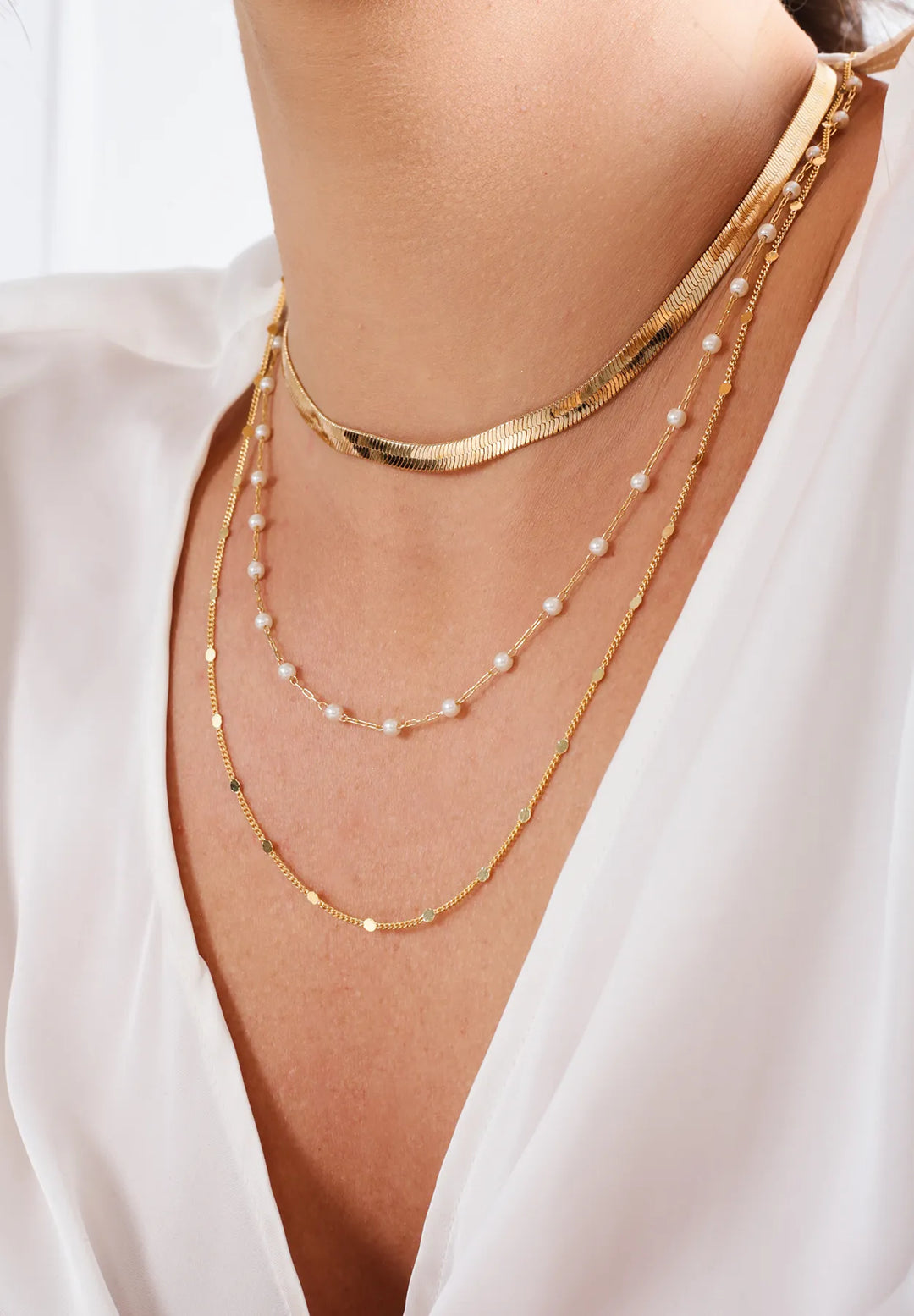 Model wearing Elladora's layered gold-filled and silver necklaces, combining timeless elegance and modern sensibility.