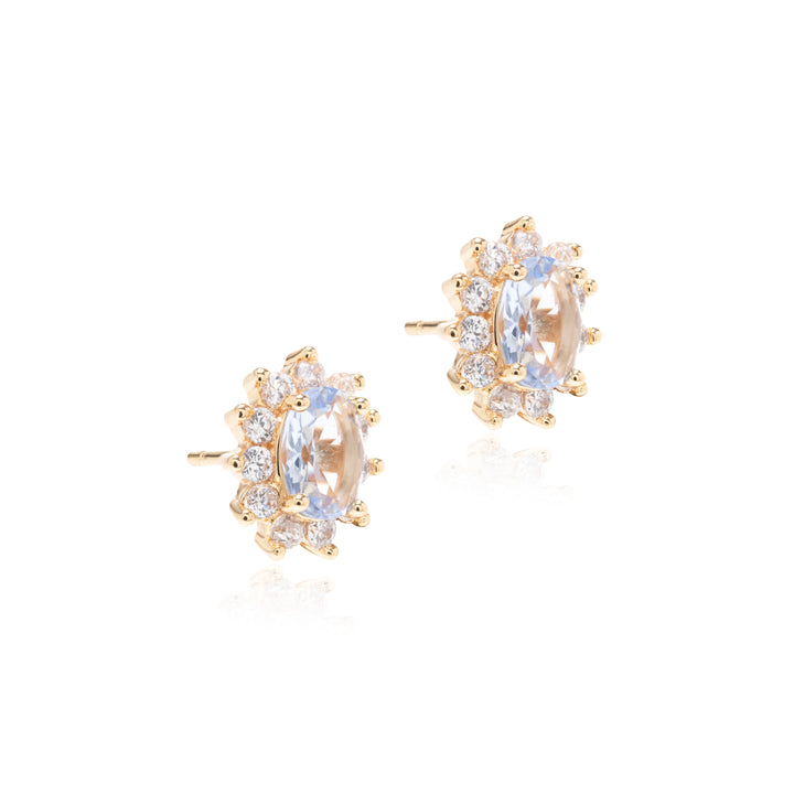A pair of gold stud earrings featuring oval clear center stones surrounded by small round clear stones, shown on a clean white background.