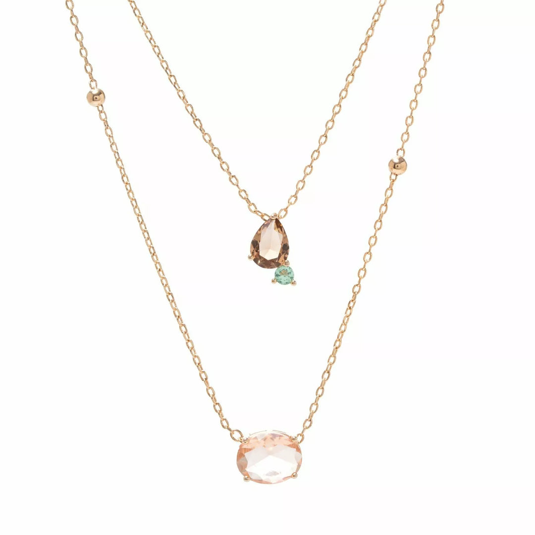 A double-layered rose gold necklace set on a white background. The shorter chain features a small pear-cut pink stone and a tiny mint green accent, while the longer chain features a larger oval pink stone pendant.