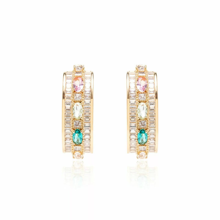 A pair of gold hoop earrings with multiple rows of clear crystals and three colorful gemstone accents in pink, green, and blue, displayed on a clean white background with a soft reflection.