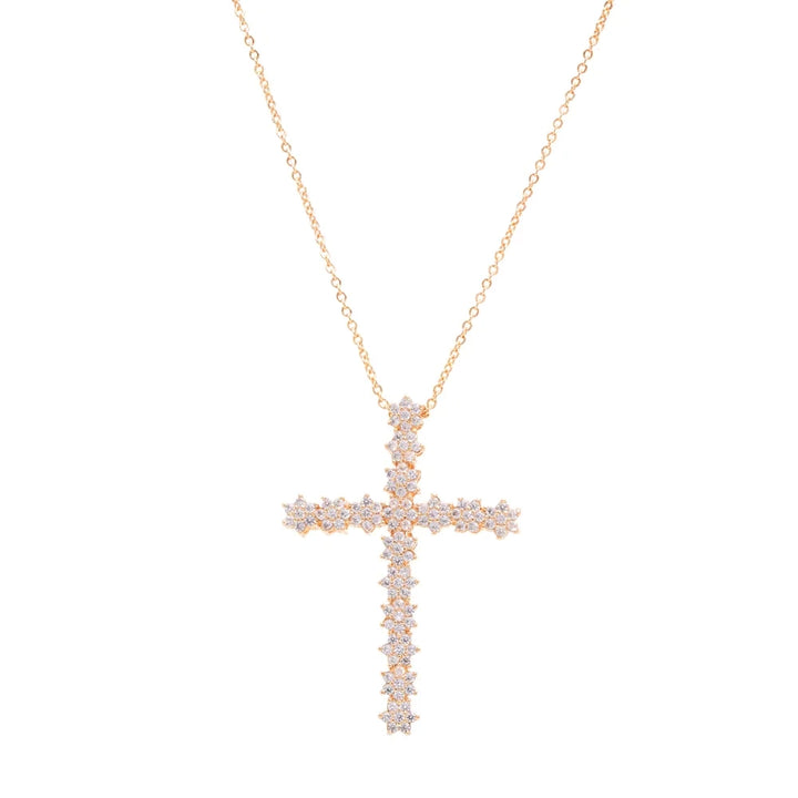 A rose gold cross pendant necklace adorned with small clear stones, suspended from a delicate rose gold chain against a solid white background.